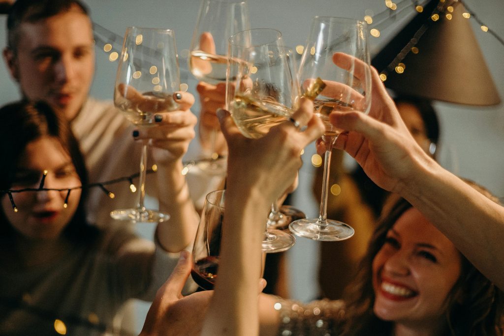 A group of friends joyfully toasting with champagne glasses at a festive celebration.